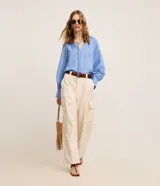 Pantalón wide leg de cintura alta en sarga de sastrería color marfil, con bolsillos cargo en los laterales y cierre frontal con botón y cremallera.