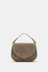 Bolso bandolera de piel gamuzada color gris topo, con solapa curva, asa de mano corta y herrajes metálicos dorados.
