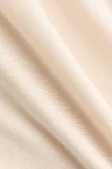 Buzo en punto fino de color beige, con escote bote y mangas largas. Cuenta con ribete fino acanalado en el cuello, los puños y el bajo.