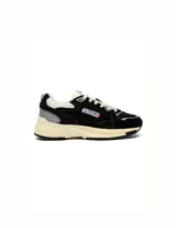 Championes Autry modelo Hyperway Low, confeccionados en una combinación de gamuza y malla en color negro. Presentan detalles en gris y blanco, con suela de goma en tono crema y logo de la marca en el lateral.
