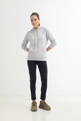 Buzo deportivo de corte clásico con capucha ajustable mediante cordones, manga larga con puños elásticos y bolsillo frontal tipo canguro.