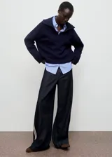 Jeans de corte wide leg y tiro bajo, confeccionados en tejido de algodón. Presentan un diseño largo con rayas laterales decorativas, trabillas para cinturón y cierre oculto de botón, gancho y cremallera.