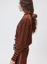 Sweater de punto jacquard con diseño texturizado, cuello alto y puños acanalados en contraste. Presenta un corte holgado y diseño inspirado en patrones naturales.