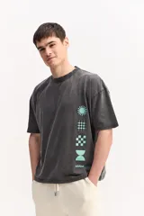 Remera de algodón marca Mistral, de corte boxy manga corta con efecto acid wash y estampas geométricas en color celeste dispuestas verticalmente sobre el frente.