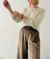 Blusa de lentejuelas color crema, de mangas largas con puños elásticos.