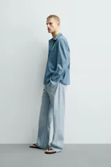 Jeans flare fit confeccionados en denim de algodón de tejido rígido, color celeste claro. Presentan diseño de cintura efecto revés, cinco bolsillos, tiro medio y cierre frontal con cremallera y botón.
