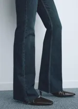 Jeans de tiro medio con diseño flare y bajo deshilachado, confeccionados en tejido elástico de algodón estilo denim. Presentan cinco bolsillos, trabillas y cierre delantero con cremallera y botón.