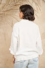 Campera color beige de lino, con cuello mao, mangas 3/4 con botón para sujetar, cierre frontal con botones y ajuste con cordón en la cintura.