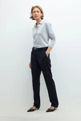 Pantalón de vestir azul marino, de corte recto, con bolsillos laterales y traseros. Se ajusta a la cintura con cinturón de cuero negro con hebilla plateada.