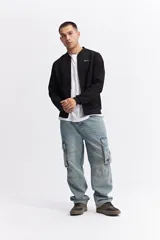 Campera tipo bomber color beige, con cierre frontal completo, cuello redondo y puños elásticos. Presenta una textura sutil en la tela y un calce cómodo.