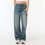 Pantalón de jean con corte baggy y pierna ancha, de tiro medio con cintura elástica ajustable mediante cordón. Presenta un lavado desgastado en tono azul medio.