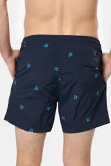 Short de baño azul marino con bordados de tortugas marinas en color celeste. Tiene cintura elástica con cordón ajustable, dos bolsillos laterales y suspensor de malla fina.