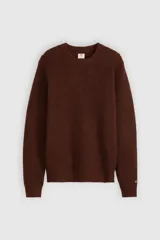 Sweater de punto con textura waffle, cuello redondo y mangas largas. Presenta un pequeño parche con logo en el puño izquierdo.