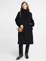 Tapado de paño negro con botones imantados y chaleco desmontable de piel sintética. Tiene bolsillos con detalle de piel sintética en el borde.