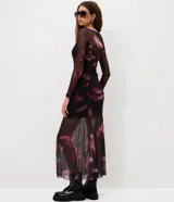 Vestido midi de tul con transparencia y estampado de efecto manchado. Presenta un diseño ajustado con mangas largas y recortes en la falda que aportan movimiento.