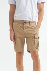 Bermuda cargo color marrón claro, confeccionada en gabardina con efecto teñido. Presenta cintura elástica con cordón ajustable y bolsillos cargo con solapa en los laterales.