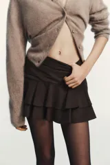Falda pantalón de tiro medio con diseño de volantes en el ruedo y cierre lateral oculto.