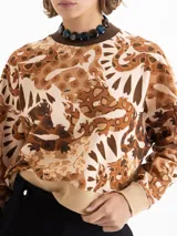 Buzo de rústico con estampado full print en tonos marrones y beige, cuello redondo tejido en color chocolate y puños y cintura tejidos en beige. De calce amplio y mangas largas.