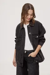 Campera de jean de silueta amplia, con cuello clásico y cierre frontal con botones. Diseño con bolsillos con solapa en el frente y bolsillos laterales, hombros caídos y terminaciones pespunteadas.