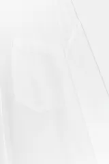 Camisa oversize de cuello solapa, confeccionada en gasa. Presenta manga larga con hombro caído y puños, bolsillo de plastrón en el delantero y cierre frontal con botones.