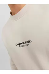 Buzo color beige de manga larga y cuello redondo con logo pequeño en el pecho. Corte relajado y tejido de bucle.