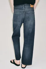 Jeans de tiro bajo con corte loose leg y largo tobillero. Presenta diseño de cinco bolsillos, cierre frontal con cremallera y botón, y acabado con efecto lavado.