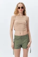 Top cropped color lila sin mangas y cuello a la base, con frunces en ambos laterales.