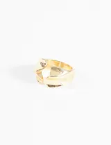 Anillo grueso de metal dorado con superficie texturada y tallada.