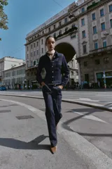 Camisa de denim color azul oscuro, de manga larga y corte entallado. Presenta cuello solapa, un bolsillo de plastrón en el pecho y cierre frontal con botones dorados.