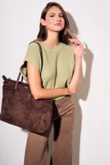 Bolso tipo tote de gamuza vegana color borgoña, con cierre superior y doble asa de cuero sintético.