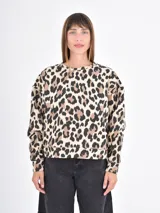 Buzo de cuello redondo y manga larga con estampado animal print de leopardo en tonos beige, marrón y negro. Presenta un corte holgado y puños y ruedo acanalados.