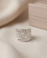 Anillo ancho de acero quirúrgico compuesto por múltiples bandas texturizadas con perforaciones circulares y detalles de brillo.
