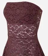 Blusa strapless confeccionada en encaje negro con diseño de bajo asimétrico con puntas diferenciadas. Presenta escote recto y forro interior.