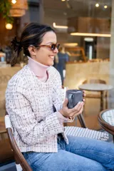 Chaqueta corta tipo Chanel de tweed color rosa, con botones fantasía y cuello redondo.