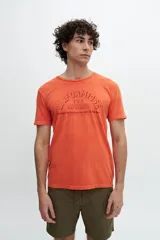 Remera color naranja con estampa tipográfica en el frente.