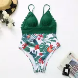 Malla enteriza con diseño combinado, parte superior en color verde petróleo con borde festoneado y parte inferior con estampado floral sobre fondo negro.
