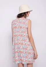 Vestido corto con estampado geométrico en tonos celeste y naranja, cuello alto, sin mangas y pequeños volados en hombros y cuello.