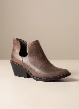 Botín de cuero vacuno color marrón con efecto desgastado, diseño de corte lateral y detalle de tachas metálicas en el borde de la suela. Cuenta con taco cuadrado de 5 cm y suela de caucho antideslizante.