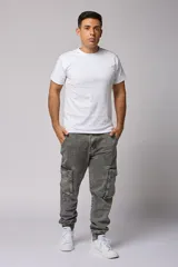 Pantalón jean gris claro, estilo jogger, con bolsillos cargo laterales y puños elásticos en los tobillos.
