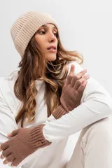 Gorro beanie tejido de punto grueso en color beige, con vuelta y pequeña etiqueta decorativa negra con la inscripción 'FEEL GOOD'.