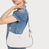 Cartera Guess modelo Noelle II de formato hobo, color beige con estampado de logo de la marca. Presenta herrajes dorados, placa triangular con logo frontal y charms colgantes. Incluye correa ajustable y cierre superior.