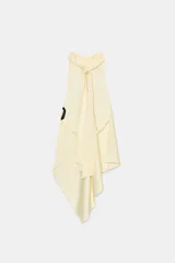 Top halter negro de tela satinada, con cuello drapeado y bajo asimétrico con caída.