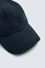 Gorra de seis paneles color azul marino, confeccionada en tejido de algodón con efecto ligeramente lavado y visera curva. Presenta ajuste posterior.