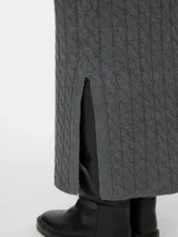 Pollera midi de tiro alto confeccionada en punto trenzado. Presenta cintura elastizada y tajos laterales en el ruedo.