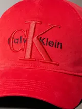 Gorra de béisbol roja con visera curva y cierre ajustable en la parte trasera. Presenta el logo de Calvin Klein bordado en relieve en el panel frontal.