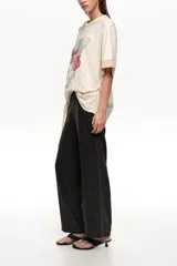 Pantalón tobillero de corte recto confeccionado en lyocell negro, con tiro medio, cierre lateral y pespuntes a contraste en los cortes verticales.