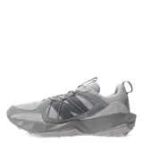 Championes de trail running New Balance modelo Tektrel, color gris con detalles en tonos más oscuros. Presentan un diseño robusto con suela AT Tread para mayor tracción, upper de malla transpirable con refuerzos sintéticos y cierre mediante cordones.