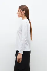 Remera de manga larga con escote redondo, confeccionada en tejido de algodón liso.