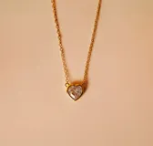Gargantilla dorada con dije de corazón con circonia transparente.