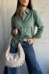 Camisa de manga larga color verde militar, con cuello camisero, cierre frontal de botones y detalles de bordados y calados en el frente y las mangas.